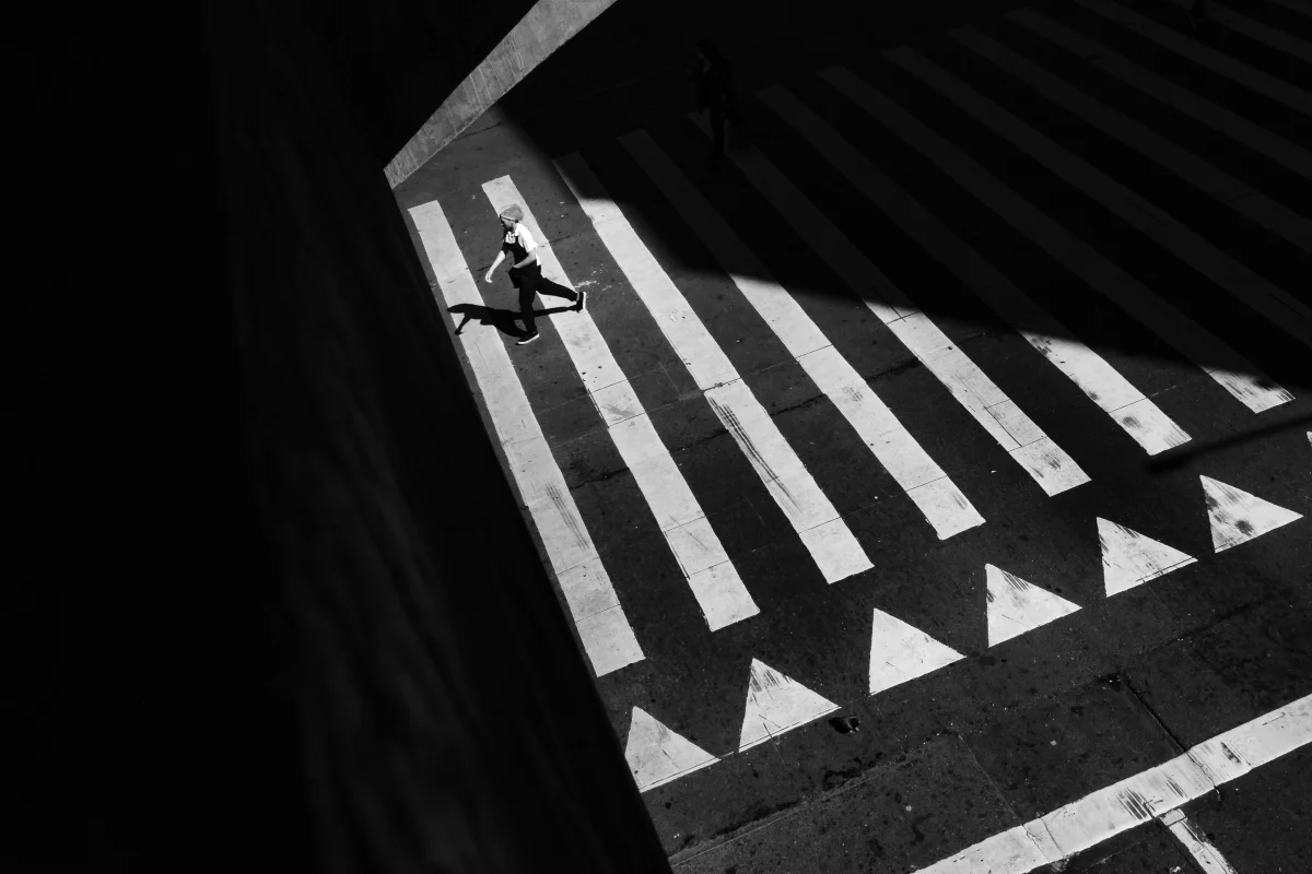 A pedestrian crossing seen from above in strong light