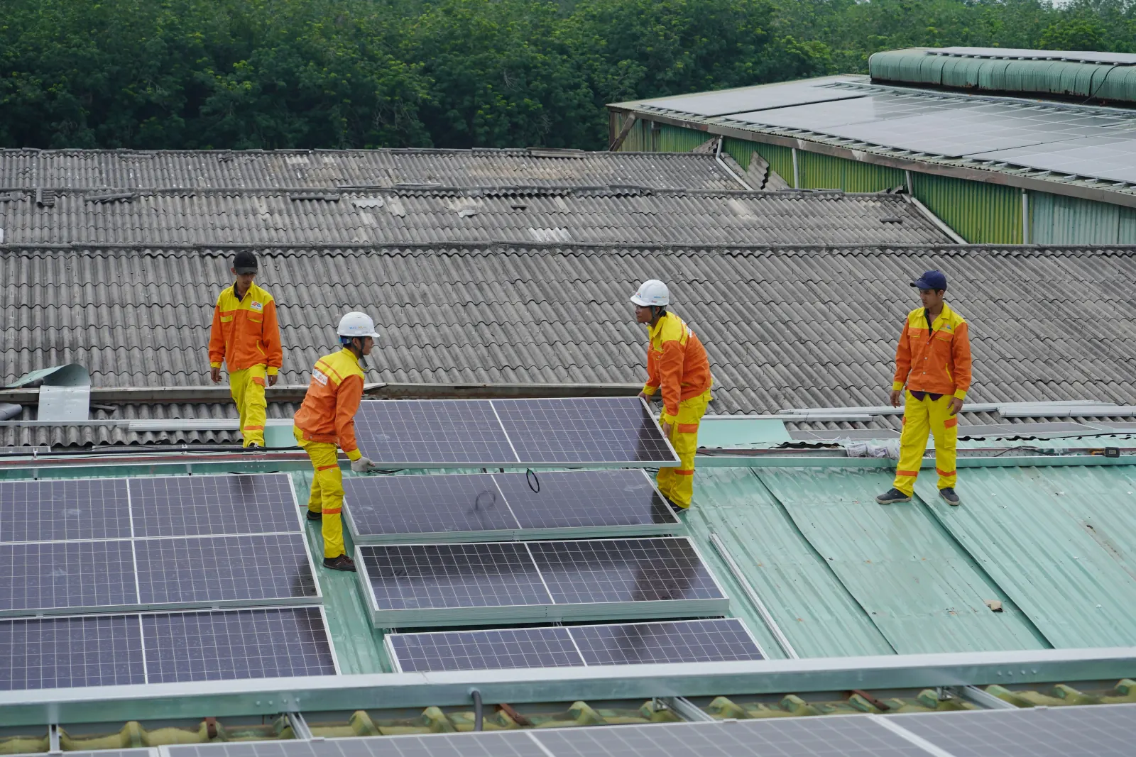 Installers positioning solar panels on a pitched roof